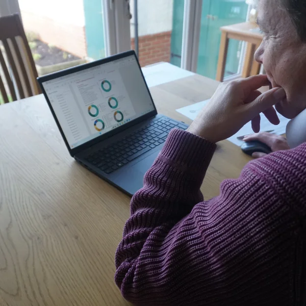 A photo of Chartered Fianncial Adviser Kris Booth taken over the shoulder as he looks at his laptop.