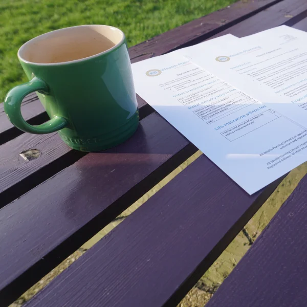 A mug and some paperwork on a bench to accomany a page about penions planning.